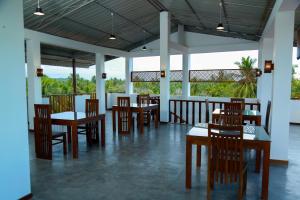un ristorante con tavoli e sedie e un balcone di BV Residence a Tangalle