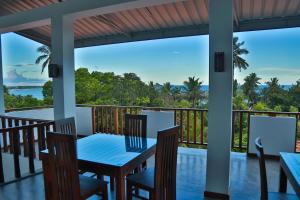 un tavolo e sedie su una veranda con vista sull'oceano di BV Residence a Tangalle