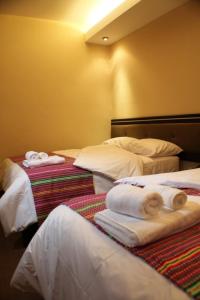 En eller flere senge i et værelse på Tampu Hotel
