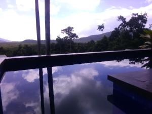 a swimming pool with a reflection of the sky at Daintree Holiday Homes - La Vista in Cow Bay