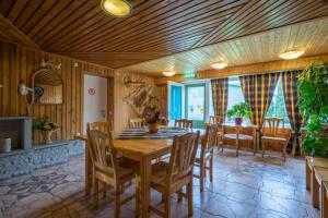 a dining room with a wooden table and chairs at Päeva Villa in Haapsalu