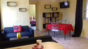 a living room with a blue couch and a table at Les Jardins de l'Ermitage in Les Salles-sur-Verdon