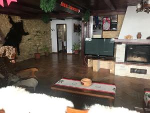 a living room with a flat screen tv and a table at Pensiunea Cerbul Carpatin in Bran