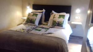 1 dormitorio con 1 cama con sábanas y almohadas blancas en Les Jardins de l'Ermitage en Les Salles-sur-Verdon