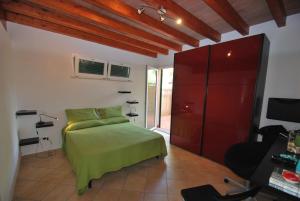a bedroom with a green bed and a red cabinet at Villetta Ciclamino in Campo nell'Elba