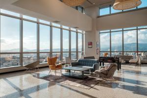 a living room with a couch and chairs and windows at amba Taipei Songshan in Taipei
