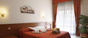 um quarto de hotel com uma cama e uma janela em Hotel Vitti em Borghesiana 