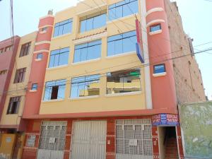 um edifício amarelo e laranja com janelas em Hospedaje San Pedro Tacna em Tacna