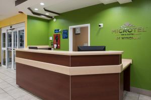 a lobby of a muppet pharmacy with a green wall at Microtel Inn by Wyndham Rogers in Rogers