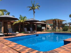 a swimming pool with chairs and umbrellas at Haven Waters Motel & Apartments in North Haven