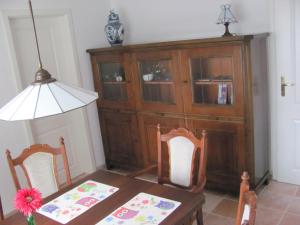 een eetkamer met een tafel en twee stoelen en een kast bij Anglerhaus Paul Rysum nähe Greetsiel - Nordsee in Rysum