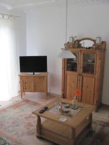 een woonkamer met een salontafel en een televisie bij Anglerhaus Paul Rysum nähe Greetsiel - Nordsee in Rysum
