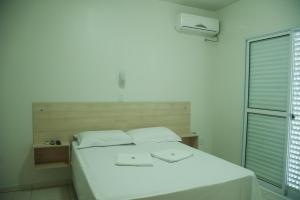 São Salvador的住宿－Pousada Pouso Ideal，一间卧室配有一张带白色床单的床和一扇窗户。