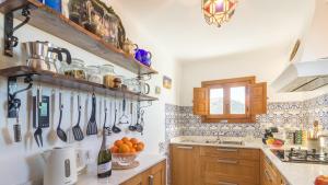 Kuchnia z kilkoma naczyniami wiszącymi na ścianie w obiekcie Casa Alta Mojacar Pueblo w mieście Mojácar