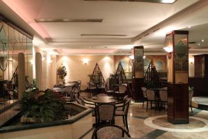 un ristorante con tavoli e sedie in una stanza di Hotel Vitti a Borghesiana