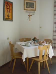 einen Esstisch mit einem Kreuz an der Wand in der Unterkunft B&B Rosalpina in Vigo di Fassa