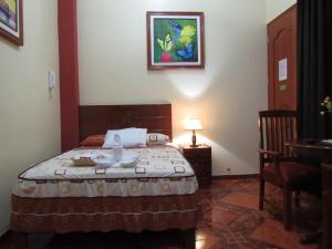 a bedroom with a bed and a table in a room at Alojamiento El Cardenal in Iquitos