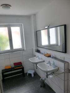 a bathroom with two sinks and two windows at Fewo Max und Moritz in Bammental