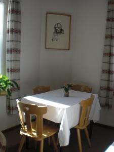 einem weißen Tisch mit Stühlen und einer Vase darauf in der Unterkunft B&B Rosalpina in Vigo di Fassa