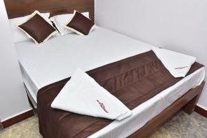 Un pat sau paturi într-o cameră la Arunaachalaa Inn