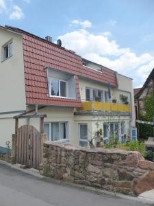 a house with a red roof and a stone wall at Fewo Max und Moritz in Bammental