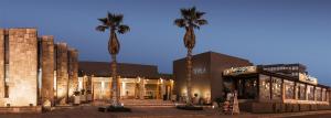 un grupo de palmeras frente a un edificio en Hotel Club La Serena, en La Serena