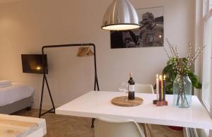 Habitación con una mesa blanca con velas y una lámpara en Da Costa Suite, en Ámsterdam
