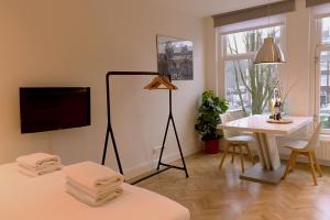 Una sala de estar con un televisor de pantalla plana y una mesa. en Da Costa Suite, en Ámsterdam