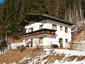 una casa en la cima de una colina nevada en Haus Nannerl, en Sankt Jakob im Lesachtal