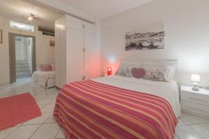 una camera bianca con un letto con una coperta colorata di Apartment Pink21 a Firenze