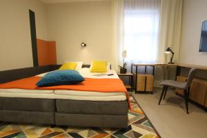 ブィドゴシュチュにあるApartamenty Garbary 3のベッドルーム1室(オレンジと青の枕が付いたベッド1台付)