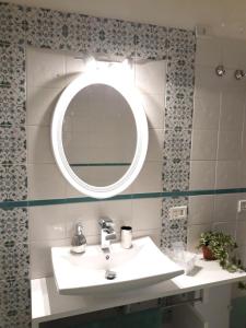 ein Bad mit einem Waschbecken und einem Spiegel in der Unterkunft Anna Home in Chiaia in Neapel