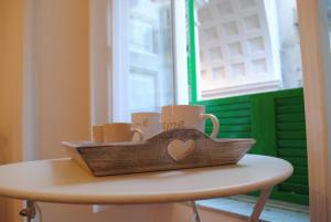 einen Tisch mit einem Tablett mit Kaffeetassen darauf in der Unterkunft Anna Home in Chiaia in Neapel