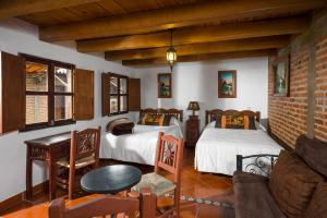 a living room with two beds and a couch at Hotel de Campiña in Tapalpa