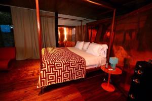 Camino del sol في Los Duarte: غرفة نوم بسرير كبير وطاولة حمراء