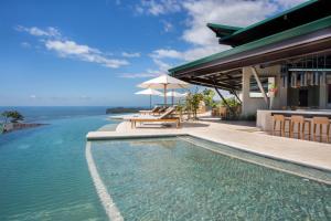 uma piscina ao lado de uma casa com o oceano em Hotel Three Sixty - Adults Only em Ojochal