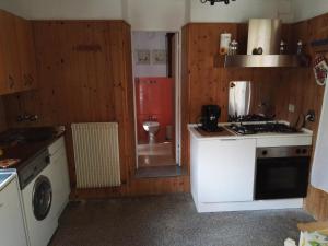 een keuken met een fornuis, een wastafel en een toilet bij Fontana's House Relax in Valbravenna