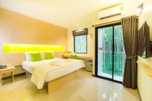 a bedroom with a bed and a large window at The Lephant Hotel in Suratthani