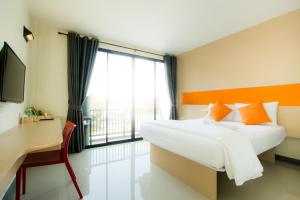 1 dormitorio con cama, escritorio y ventana en The Lephant Hotel en Surat Thani
