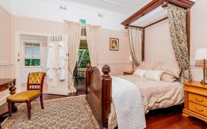Un dormitorio con una cama con dosel y un escritorio. en Ithaca, en Grafton