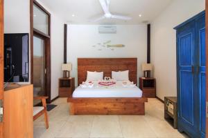 a bedroom with a large bed with a blue door at Ningaloo Villa in Gili Trawangan