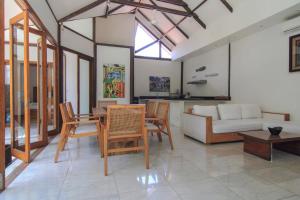 a living room with a table and chairs and a couch at Ningaloo Villa in Gili Trawangan