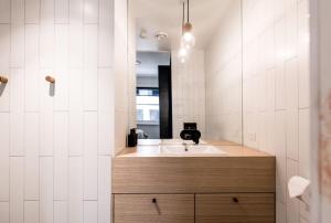 a bathroom with a sink and a mirror at 105 Mac Unique Apartments in Hobart