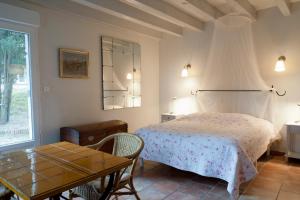 a bedroom with a bed and a table at Ecuries Sainte Croix in Carcassonne