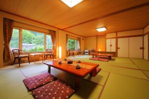 a living room with a table and a large window at Sanseikan in Noboribetsu