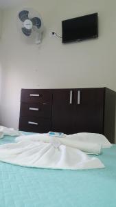 a bedroom with a bed with a tv on the wall at Continente Boutique in San Clemente del Tuyú