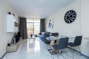 sala de estar con mesa y reloj en la pared en Luxury Appartements Playa Paraiso, en Playa Paraiso