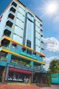 فندق مافريك راتشادا في بانكوك: مبنى طويل مع الشمس في السماء
