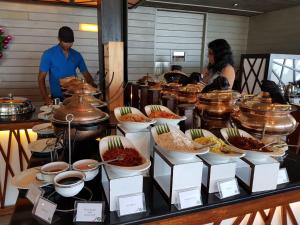 a buffet with many bowls of food on a table at Hikka Tranz by Cinnamon in Hikkaduwa