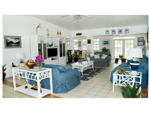 a living room with a blue couch and tables at Silver Point Villa in Freeport